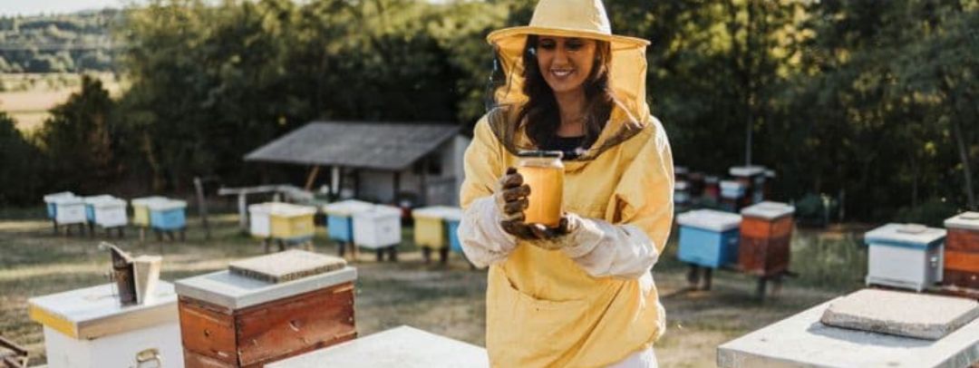 apicultora con bote de miel